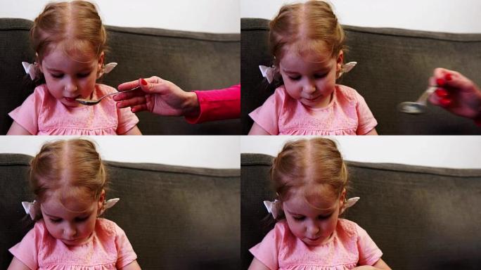 一个小女孩在被喂食时无法将视线从智能手机上移开