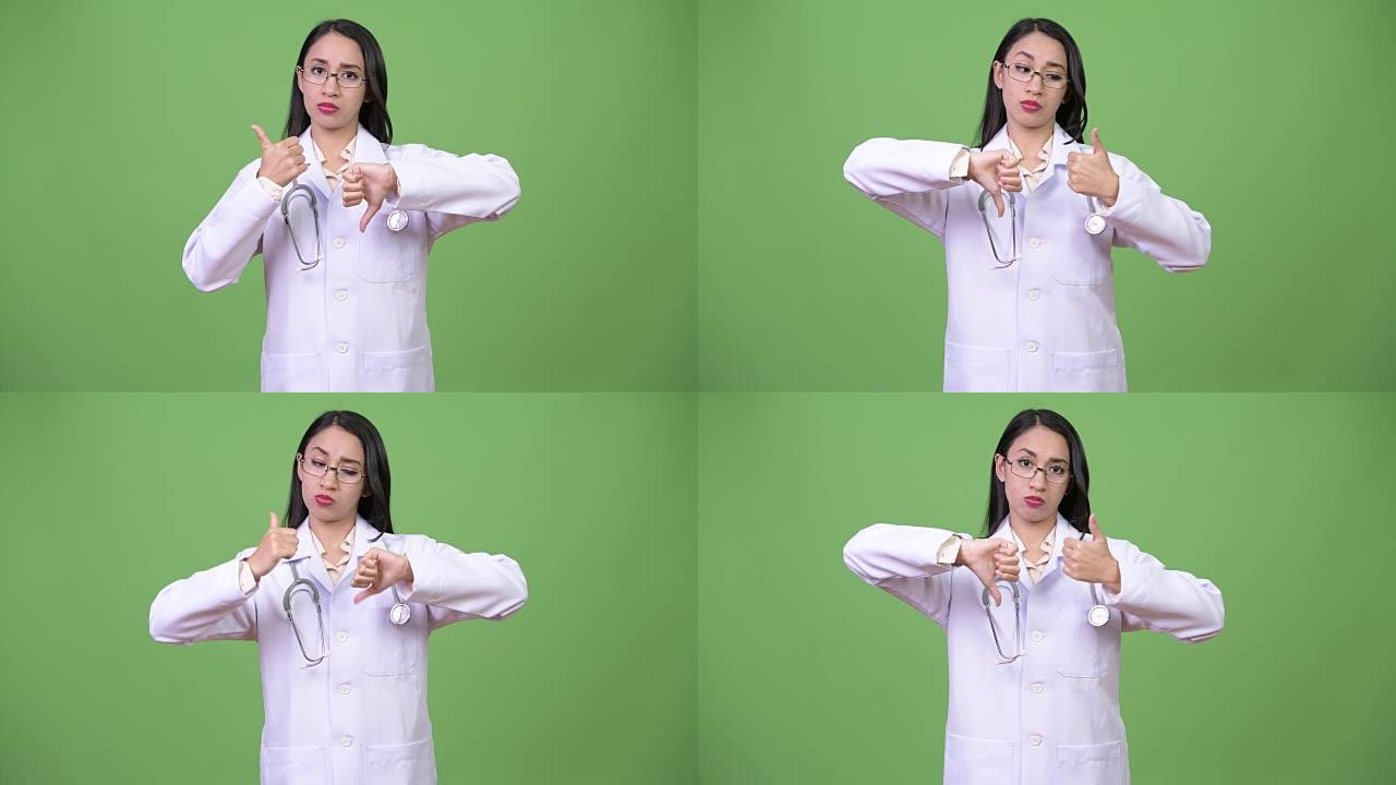 年轻美丽的亚洲女医生在竖起大拇指和竖起大拇指之间选择