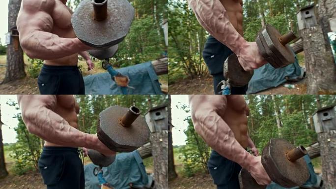 重铁手工哑铃在森林中肌肉发达的人的手中锻炼
