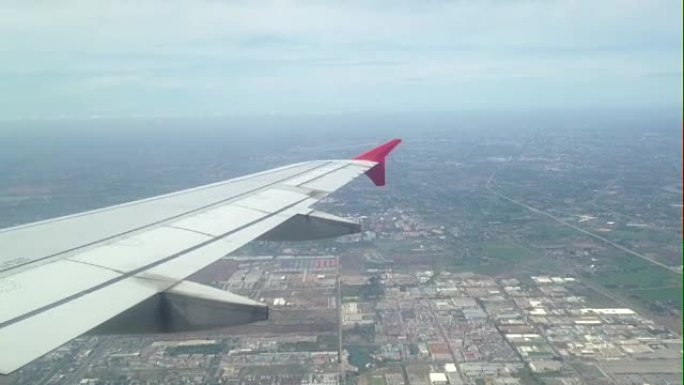 一架飞机下午在泰国曼谷市上空飞行的场景
