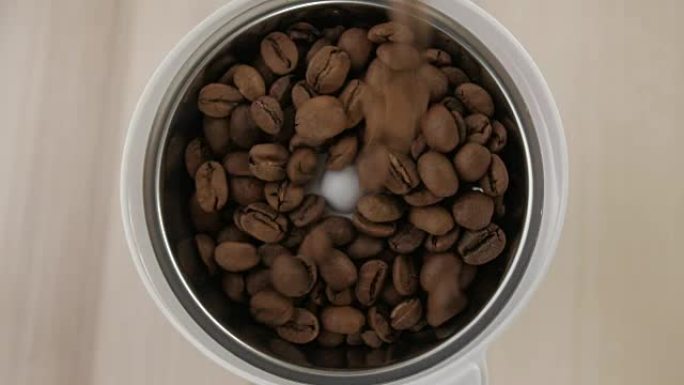 倒了咖啡豆。烤咖啡豆倒入咖啡研磨机。特写