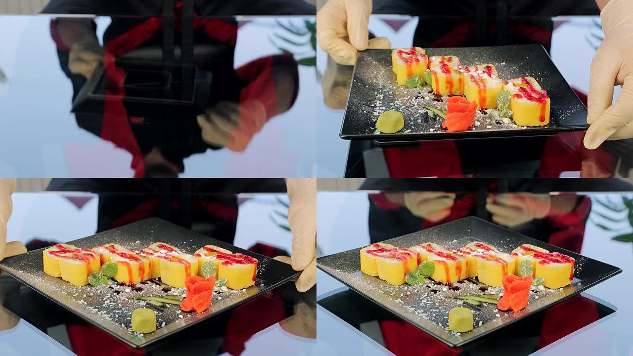黑色盘子上的寿司装饰着生姜玫瑰