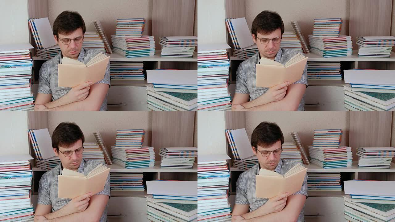 戴眼镜的年轻黑发男人坐在书里看书。