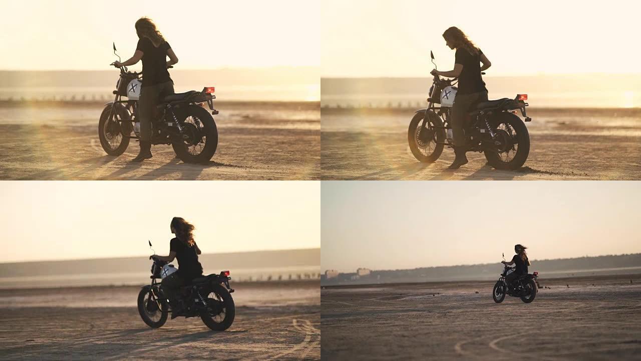 美丽的年轻女子骑着一辆旧摩托车，在耍花招。日落或日出时在沙漠中。女自行车手。稳定射击