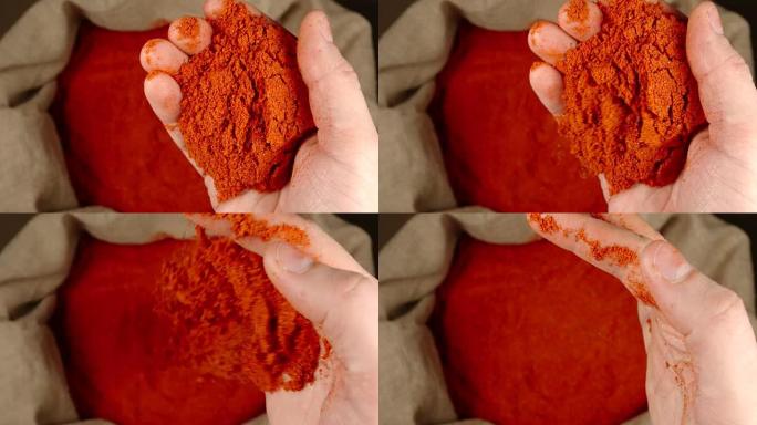 顶视图: 人的手将少量的红辣椒粉放在囊上并将其扔出-慢动作