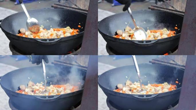 在街头美食节上，美味多汁的肉与蔬菜一起在大碗中油炸，并用勺子混合