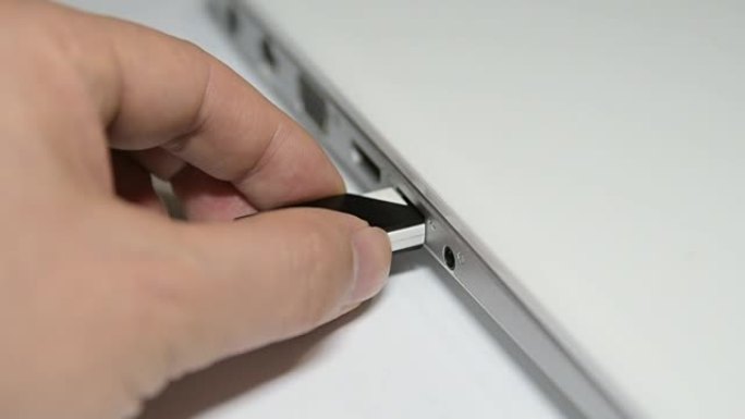 将USB闪存插入和拔出笔记本电脑。
