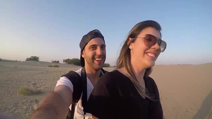 夫妇在沙漠中骑骆驼自拍照