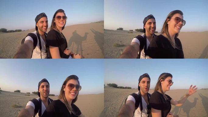 夫妇在沙漠中骑骆驼自拍照