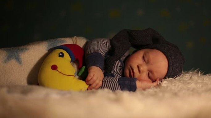 小孩，小男孩，可爱的泰迪熊和月亮在蓝色的星星和月亮背景下，睡觉