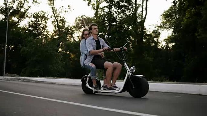 一对夫妇骑自行车玩得开心的侧视图。美丽的年轻男女开车环游城市。自由，快乐的生活方式