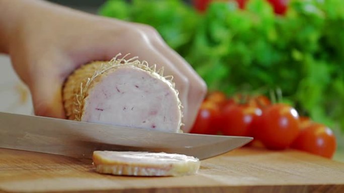 Female hands cut ham into thin slices