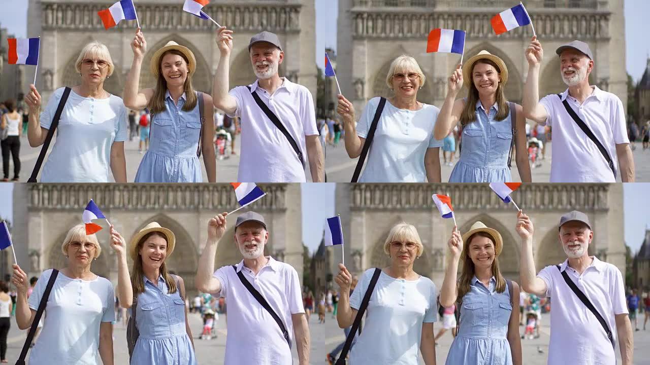 快乐的家庭享受假期。巴黎圣母院附近的年长者和他们的女儿。挥舞法国国旗