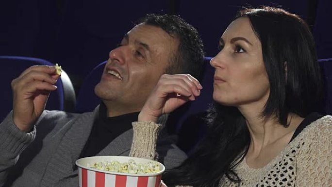一对成熟的夫妇在电影院一起看电影的特写