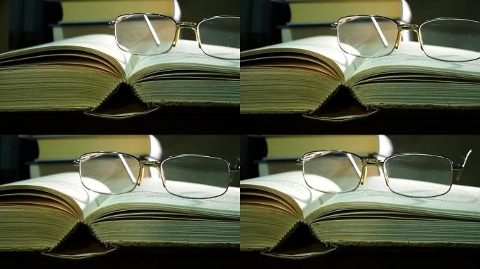 用旧桌子上的眼镜打开书。滑。