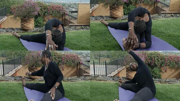 灵活的资深非裔美国妇女做瑜伽姿势和伸展运动