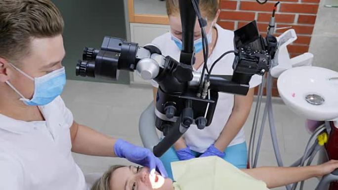 医学检查，现代显微镜专家正在牙科诊所为牙齿酸痛的妇女进行手术