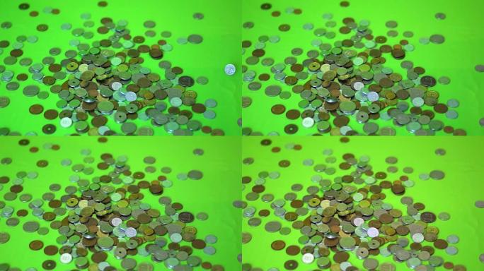 硬币落在绿色背景上，慢动作