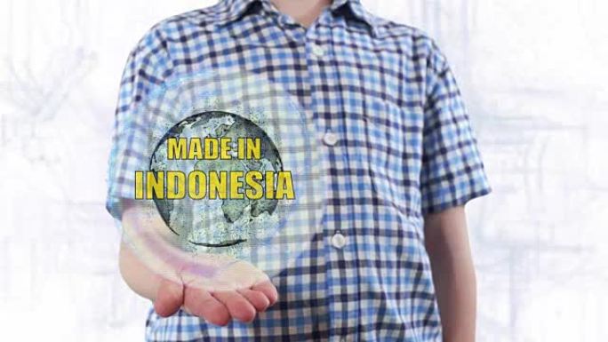年轻人展示了地球的全息图和印度尼西亚制造的文字