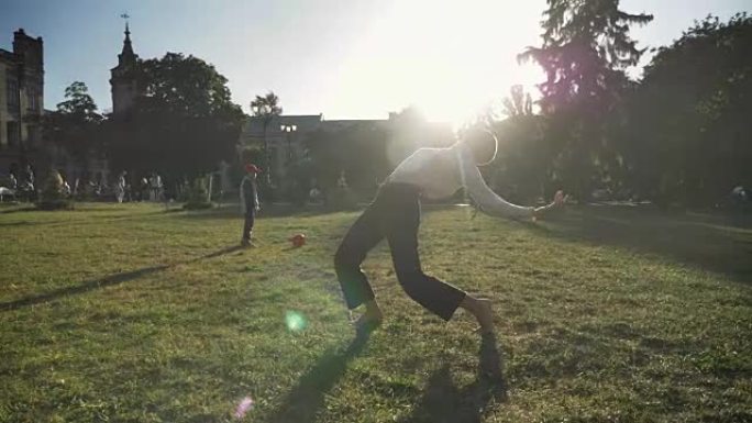 年轻非凡的大胆女孩芭蕾舞女演员在夏天的白天在公园的草地上跳舞，运动概念