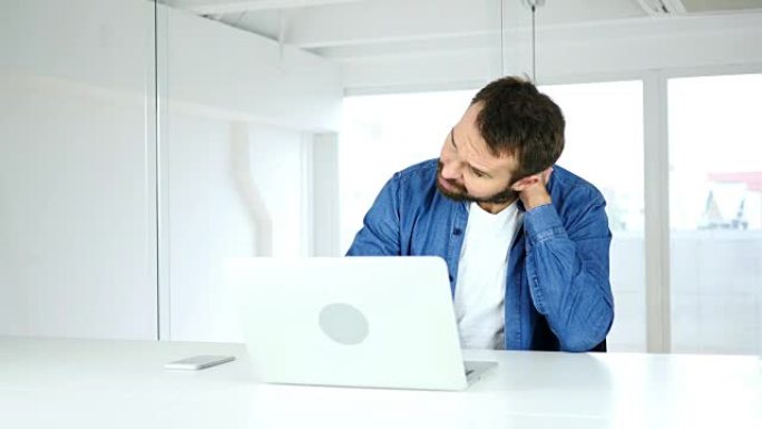 疲倦的人试图放松颈部僵硬的肌肉，在笔记本电脑上工作