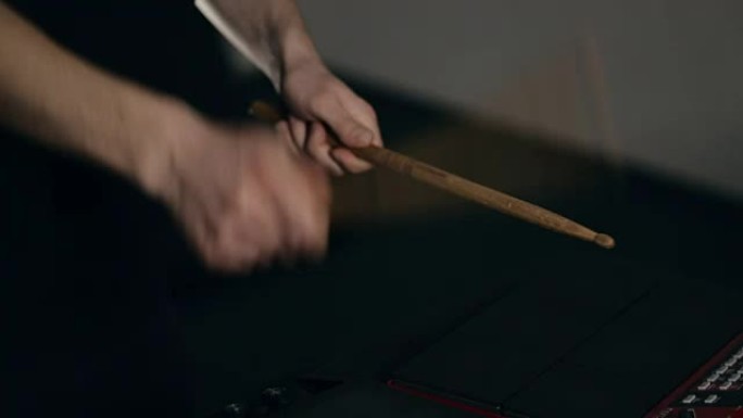 音乐家的手在带有鼓槌的电子垫上演奏