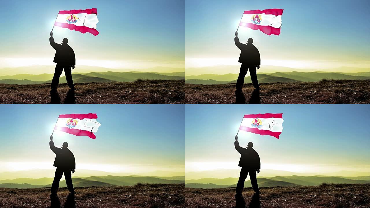 成功的剪影男子冠军挥舞着法国波利尼西亚国旗在山顶。Cinemagraph循环背景