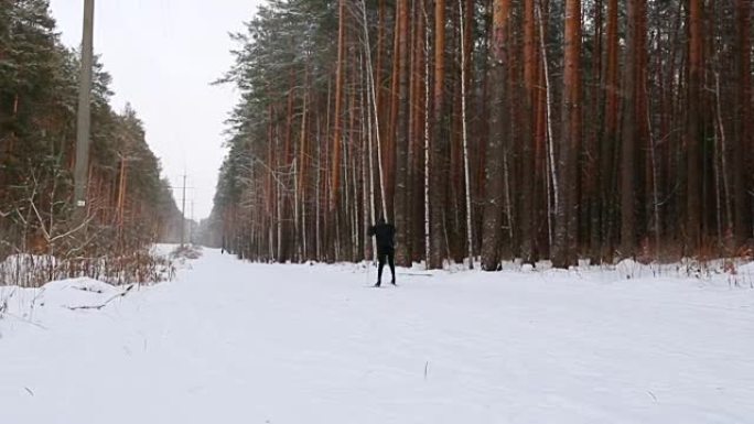 Skier moving along ski-track through the winter pi