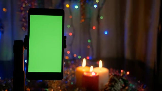 新年的背景，在前景的智能手机与绿屏。一个很好的机会来添加你的问候视频。