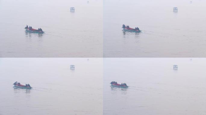 渔民骑着蓝色船在早晨雾蒙蒙的时候钓鱼。在进入大海之前，渔民在河口的海中用竹子建造的传统房屋的景色。