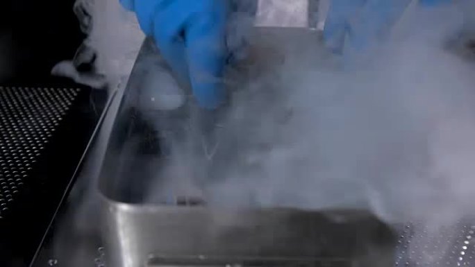 医生用热水对容器中的医疗器械进行消毒