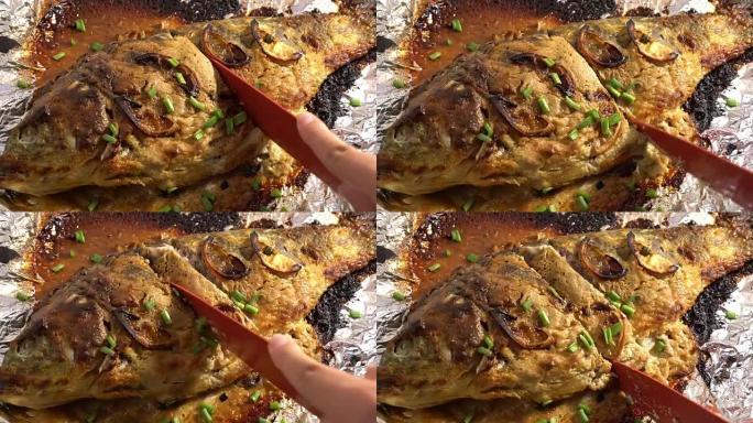 鲤鱼用西红柿和蔬菜在明火上烤过，躺在木板上，酱汁准备吃，烤鱼，烧烤和烧烤，在外面做饭，夏天的饭菜，乡