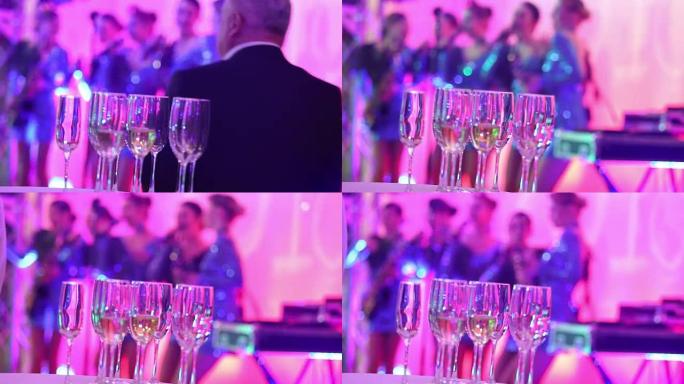 女子音乐团体剪影背景上的香槟眼镜，女子音乐乐队在餐厅或酒店大堂表演