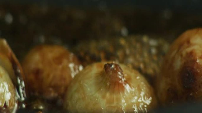 A chef is sauteeing sweet onions in an iron pan