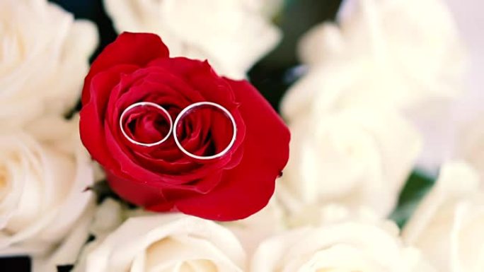 一束玫瑰上的结婚戒指。新婚夫妇的珠宝。婚礼配件