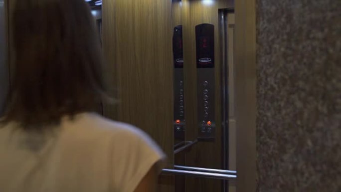 电梯门打开，一个女人进入。