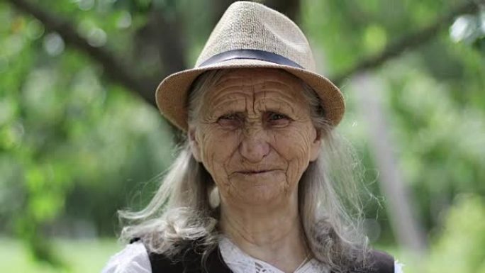 户外一位戴着草帽的白发老妇的肖像。