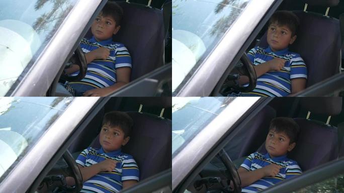 这个男孩坐在汽车的方向盘上
