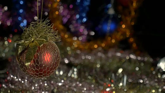 一个美丽的红球。新年和圣诞装饰品。闪光花环。背景模糊。