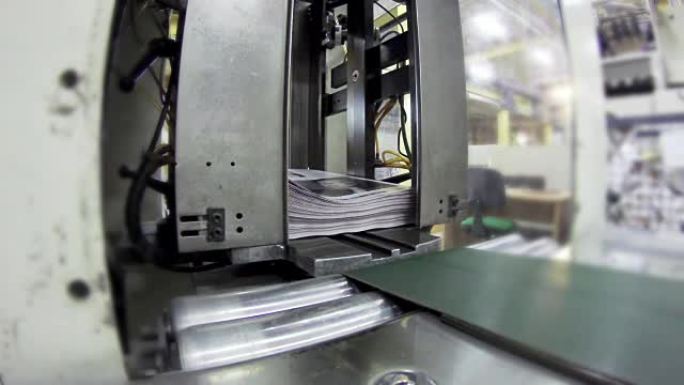 印刷厂工厂，杂志线收集后，将压辊送入印刷单元和文件夹。UHD股票视频
