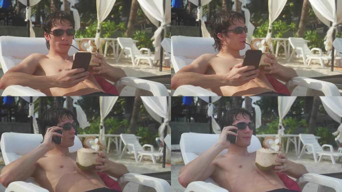 年轻人躺在热带海滩上晒日光浴时会说手机。3840x2160