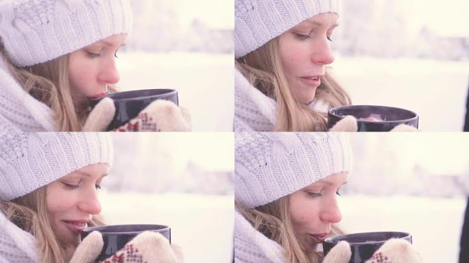 美丽的年轻女孩在公园外面喝热巧克力，闻起来很暖和。舒适的概念。全高清FHD 3840 2160慢动作
