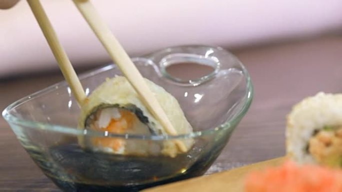寿司保持筷子，蘸酱。