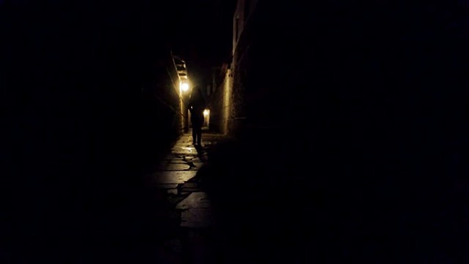 一个女人走在黑色小巷里的剪影