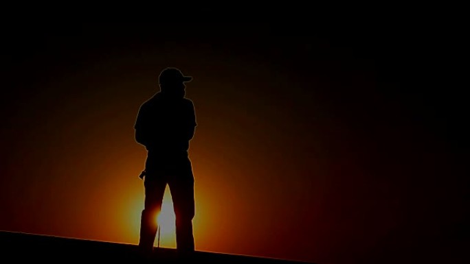 男性高尔夫球手将在夕阳的温暖光线下进行一轮高尔夫比赛前检查风向
