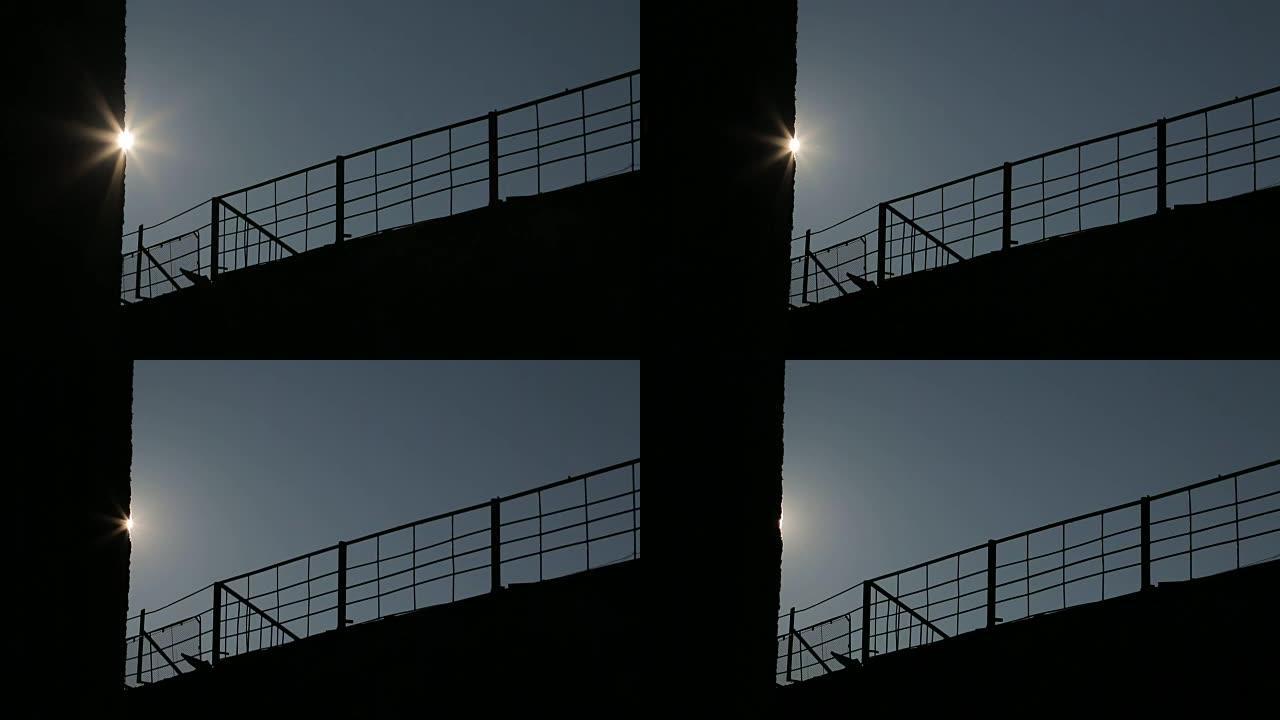 背景。太阳背面的金属栅栏。摄像机运动。阳光照亮了栅栏。