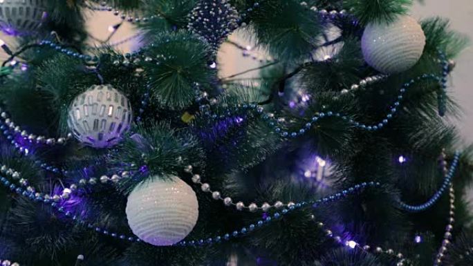 蓝色灯光装饰的圣诞树。白色圣诞球和花环