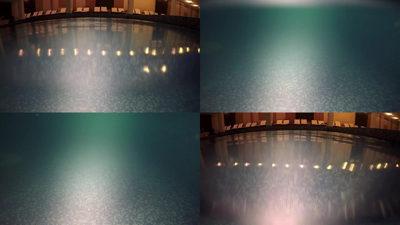 泳池表面在夜晚的黑暗气氛中，酒店水疗中心。查看水下和外出