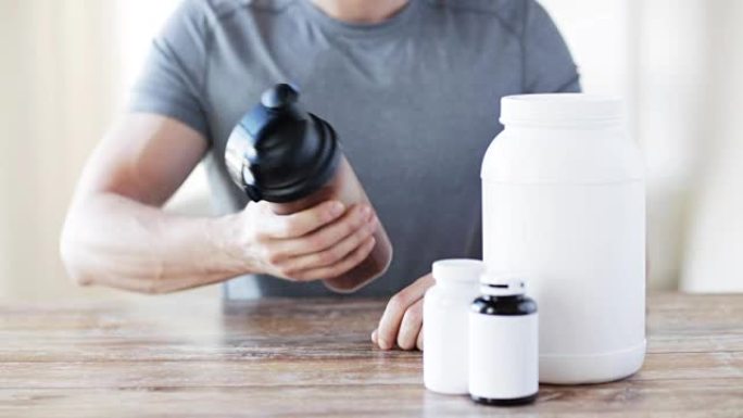 健身追踪器中的男人，用罐子和瓶子准备蛋白质奶昔