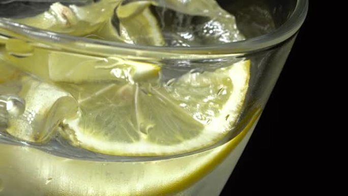 Glass of water with ice and lemon in rotation